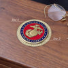 United States Marine Corps coin on a wooden surface with glasses in the background
