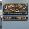 Two decorative wooden signs hanging on a light blue-gray wall. The top sign reads 'FAA CERTIFIED - ICAO LICENSED AIR TRAFFIC CONTROLLER' with ornate gold detailing, a gold airplane sculpture, and additional text.
